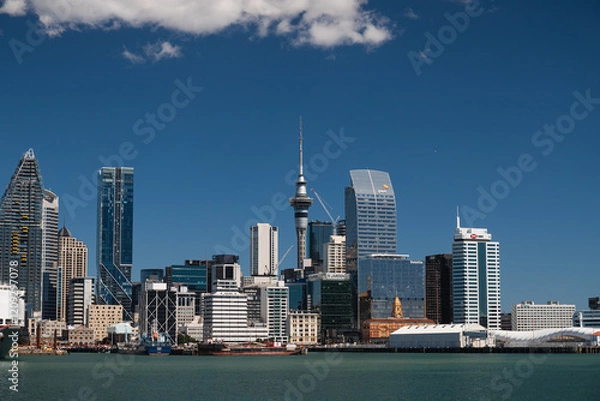 Obraz View onto skyline of Auckland as seen from a ferry towards Devonport on a summer day with perfect blue sky (Auckland, North Island, New Zealand)