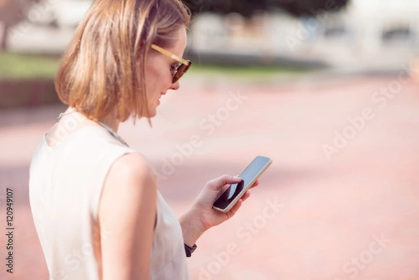 Fototapeta Attractive young woman using phone