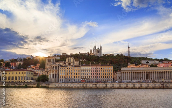 Fototapeta Colorful sunset at Vieux Lyon and Fourviere Basilica seen from the riverbank of the Saone, Lyon.