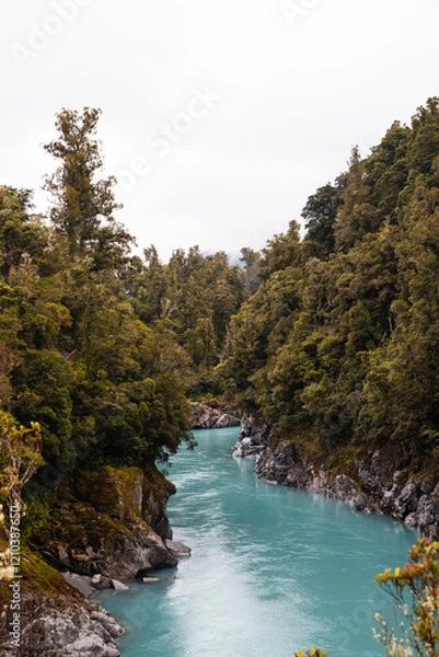 Obraz Turquoise calm water in Hokitika Gorge with fogs rolling through lush green forests on a rainy summer day (South Island, New Zealand)