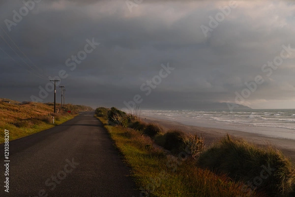 Obraz View of beautiful sunset on the shore of Cape Foulwind with beach views and rolling dark clouds (Cape Foulwind, South Island, New Zealand)