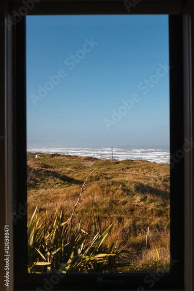 Obraz Window view onto shore of Cape Foulwind as seen from within with waves crashing on the beach (Cape Foulwind, South Island, New Zealand)