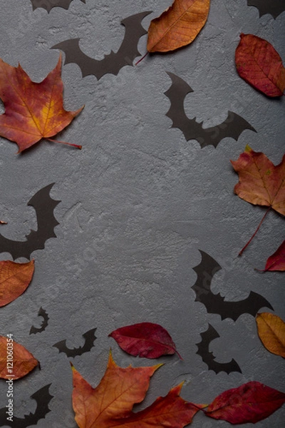 Fototapeta Halloween background with paper bats and autumn leaves. Top view with copy space