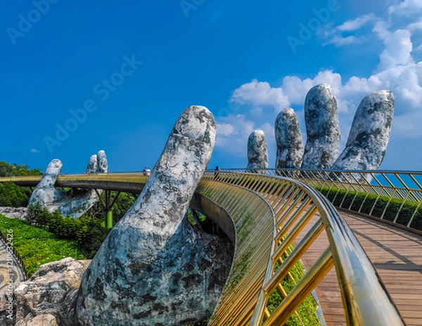 Obraz Golden Bridge in Ba Na hills, Da Nang, Vietnam on a sunny day. Lifted by two giant concrete hands. Iconic world famous bridge in the mountains