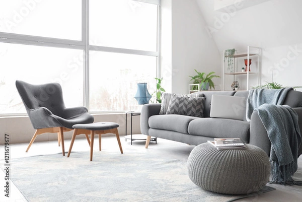 Fototapeta Stylish interior of white living room with black sofa and armchair