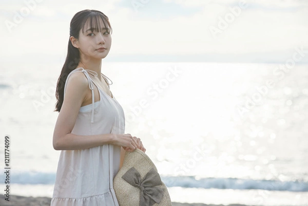 Fototapeta 海辺を散策する若い女性