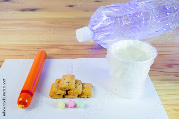 Obraz ビニール袋でカバーされた水が入った紙コップと避難所での一食の配給食料