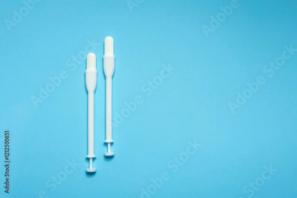 Fototapeta Vaginal suppositories on a blue background. Caring for women's health. Close-up. Selective focus. Flat lay. Place for text