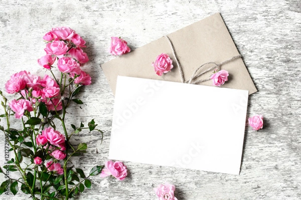 Fototapeta Bouquet of roses with a blank greeting card and envelope