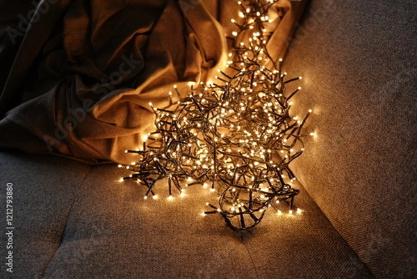 Obraz Warm christmas lights illuminating cozy sofa with blanket