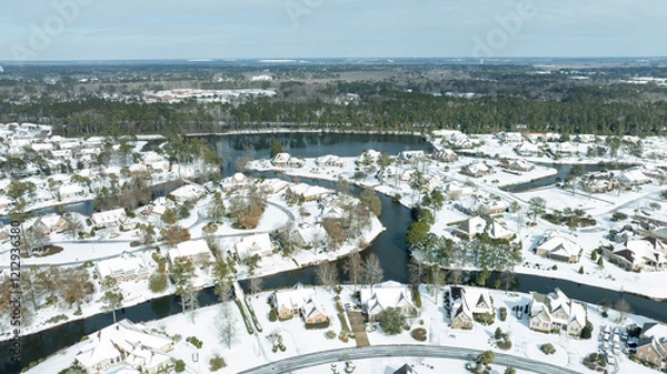 Obraz Aerial views of a snow-covered suburban neighborhood with houses, roads, ponds, and recreational facilities.