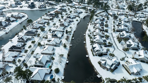 Obraz Aerial views of a snow-covered suburban neighborhood with houses, roads, ponds, and recreational facilities.