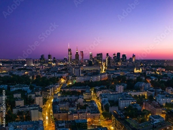 Fototapeta City skyline of Warsaw illuminated at dusk with a vibrant sky and busy streets below showcasing urban life