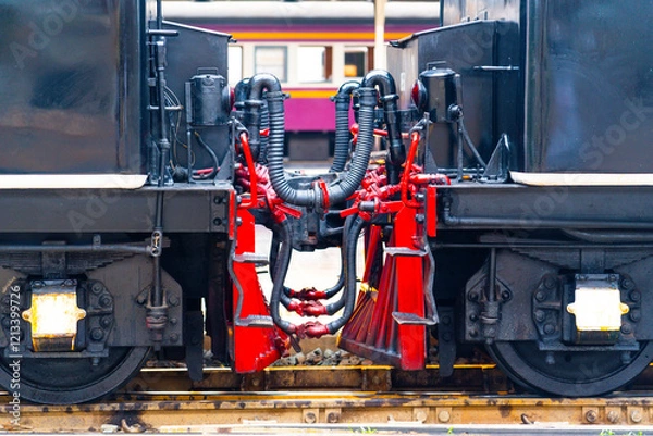 Fototapeta Chain coupler connecting freight wagons retro steam locomotives close up, large wagon buffers visible.