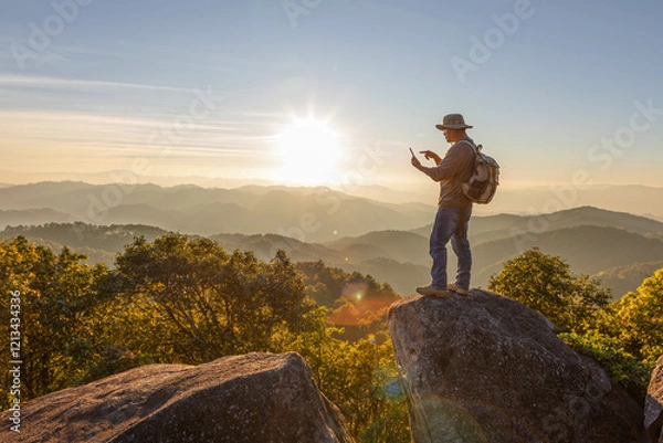 Obraz Hiker with backpack checks map on smartphone to find directions in wilderness area on top mountain.Hiker man hiking living healthy active lifestyle.