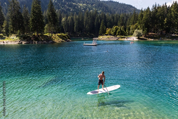 Fototapeta Man on a paddleboard at Caumasee, Switzerland