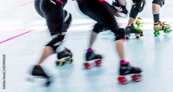 Fototapeta Roller derby skaters action blur. Motion pan shot at rink competition.