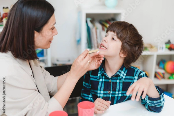 Obraz Cute preschool child is engaged in speech therapist office and correcting his speech