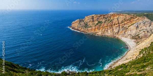 Fototapeta Bay, cove or inlet in Cabo Espichel Cape and a view over the Atlantic Ocean. Seascape of a natural beach surrounded by cliff. Sesimbra, Portugal