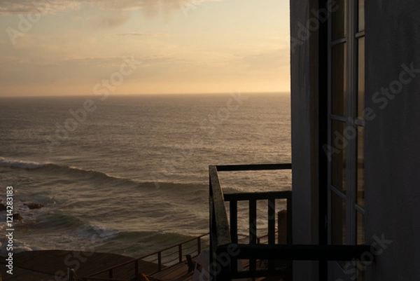 Fototapeta A glimpse of the ocean through a window at sunset