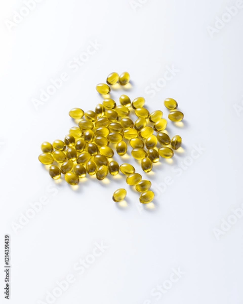 Fototapeta Yellow capsules with vitamins on a white background