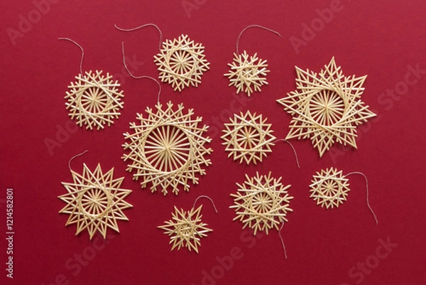 Obraz Snowflakes are made of straw on a red background. Christmas decor. Top view. Straw weaving. Lutsk, Ukraine