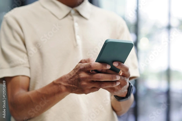 Fototapeta Close-up of businessman texting message on his smartphone and communicating online