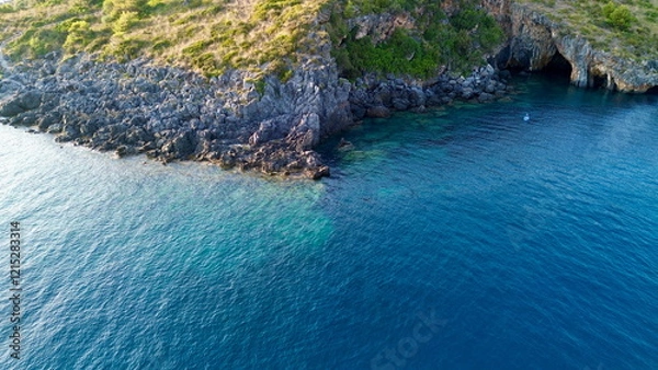 Fototapeta Cinematic aerial view from top about a white little boat running in a hypnotic blue colored sea