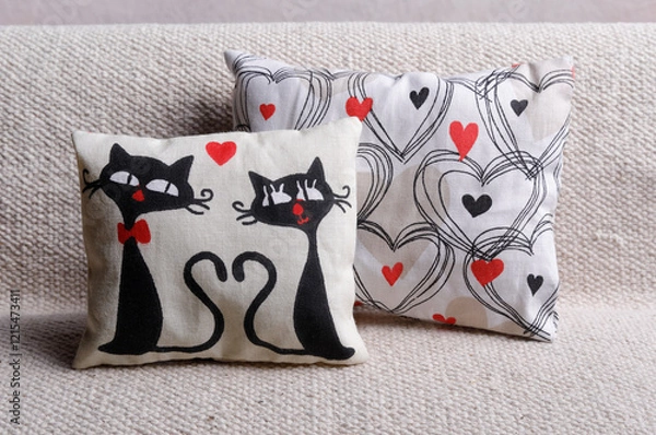 Obraz Cushions with two black cats and heart shape on sofa