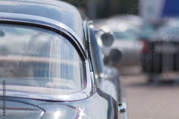 Fototapeta Close-up of an old car. Part of the exterior. An American classic. Chrome lining. Glass with reflection.