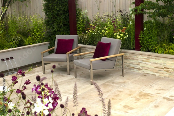Obraz Tranquil garden with a patio and two seats