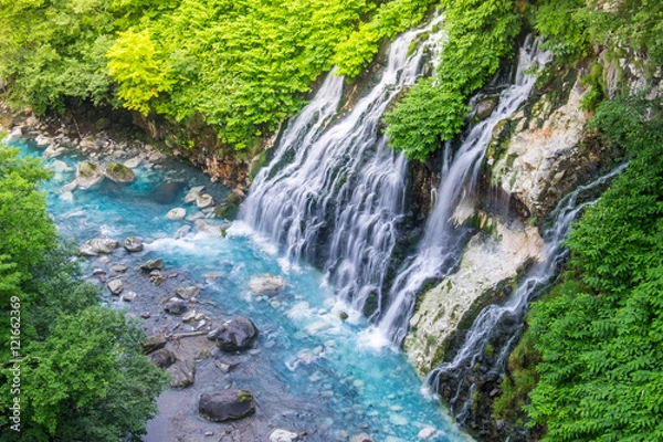 Fototapeta Shirogane waterfall with blue stream at Biei, Japan