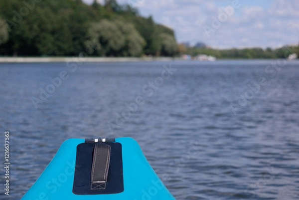 Fototapeta Close up view of fore part of inflatable kayak in the middle of wide calm river in summer day