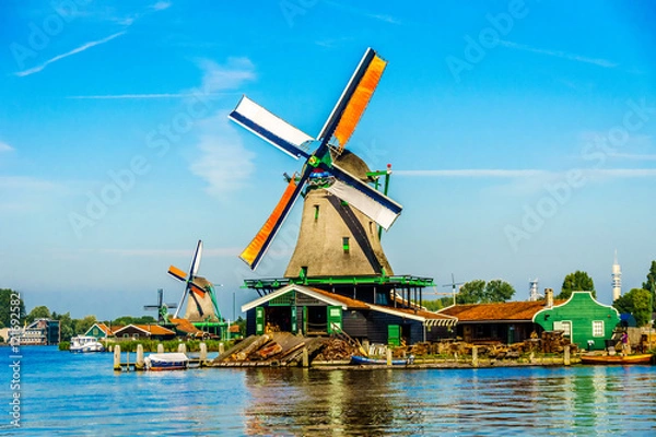 Fototapeta Fully operational historic Dutch Windmills along the Zaan River at the village of Zaanse Schans in the Netherlands