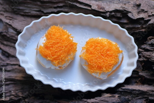 Fototapeta Donuts with Sweet egg floss in a white plate on a wooden background
