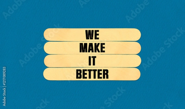 Fototapeta We Make It Better Symbol. Concept word We Make It Better on beautiful wooden stick. Beautiful Blue Chart Paper Background. Business and We Make It Better concept. Copy space