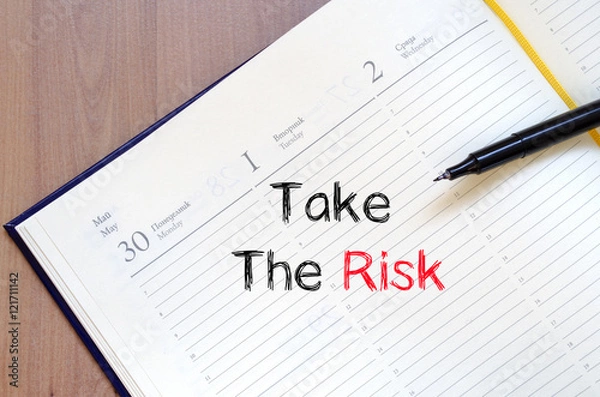 Fototapeta Take the risk text concept on notebook