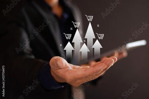 Fototapeta Sales Growth Businessman holding graph showing increase in sales volume with shopping cart on screen and percentage growth of ecommerce business.