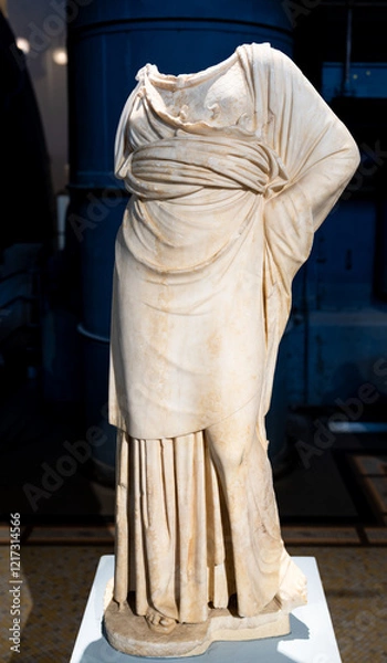 Fototapeta Headless marble statue portraiting an ancient roman person posing in a tunic