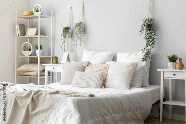 Fototapeta Cozy bed with soft pillows in interior of light bedroom
