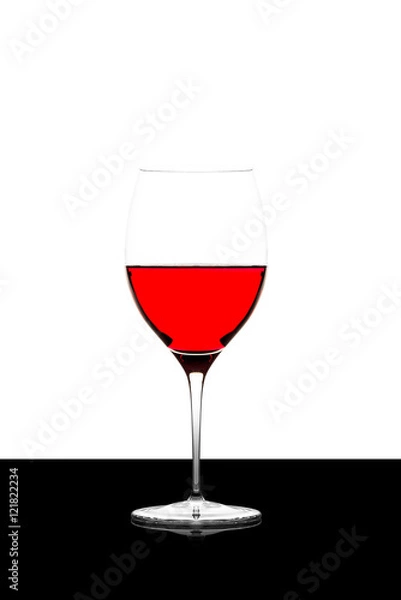 Fototapeta red wine glass on a  black board isolated and backlit