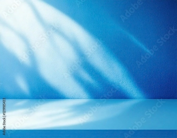 Obraz sunlight streams through a window, casting abstract patterns on a bright blue wall. a  white shelf sits in the foreground, inviting the viewer to imagine the possibilities