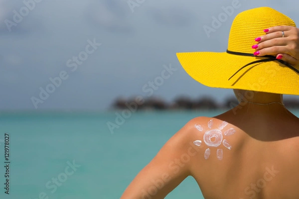 Obraz Woman with sun-shaped sun cream on beach