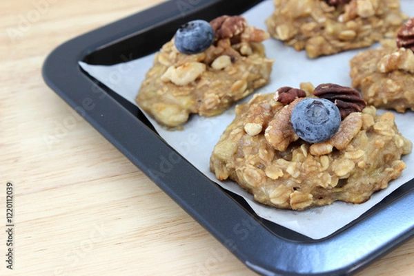 Obraz Homemade oat and banana cookie topping with blueberry, walnut and pecan on the oven tray, dessert for vegan