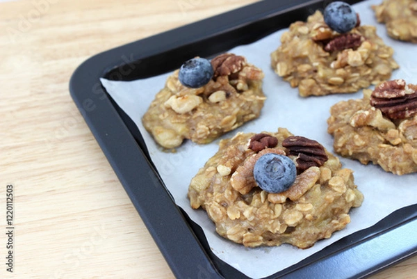 Obraz Homemade oat and banana cookie topping with blueberry, walnut and pecan on the oven tray, dessert for vegan