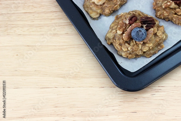 Obraz Homemade oat and banana cookie topping with blueberry, walnut and pecan on the oven tray, dessert for vegan