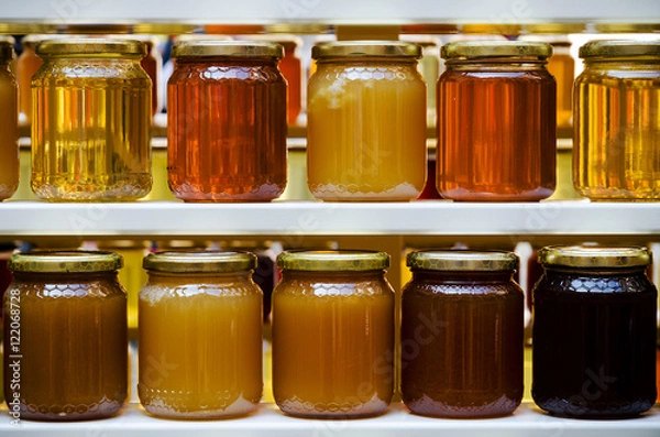 Fototapeta Jars of different honey varieties stocked on a shelf