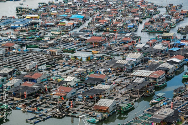 Fototapeta fishing village of poor people on the sea water in island Hainan in China
