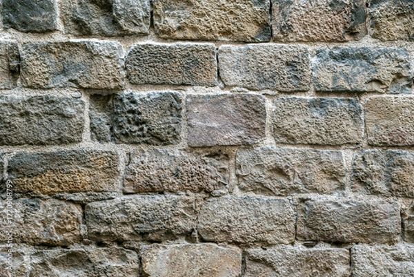 Fototapeta Fragment of an old wall made of rough gray stone blocks for use as an abstract background and textures.