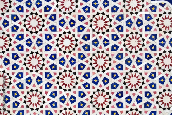 Fototapeta A detailed Islamic geometric mosaic featuring vibrant colors and symmetrical patterns. The design showcases traditional arabesque motifs with star shapes and interwoven lines